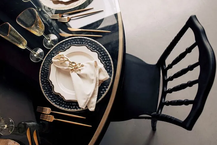 Black-white table setting with gold at round table