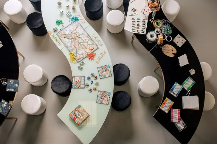 Black and white serpentine tables with velvet poufs
