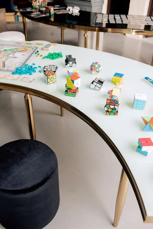 Black and white serpentine tables with velvet poufs
