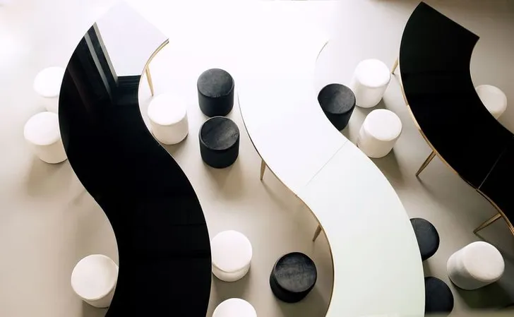 Black and white serpentine tables with velvet poufs