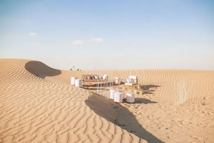 Pink desert lounge setup with ottomans