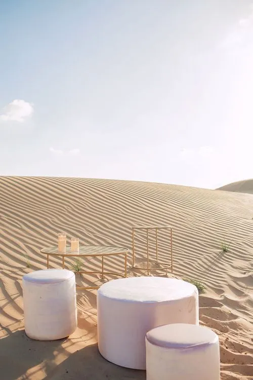 Pink desert lounge setup with ottomans