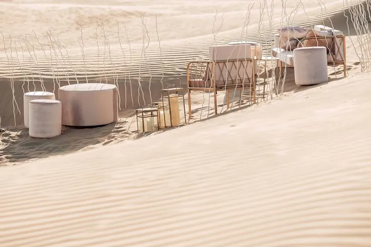 Pink desert lounge setup with ottomans