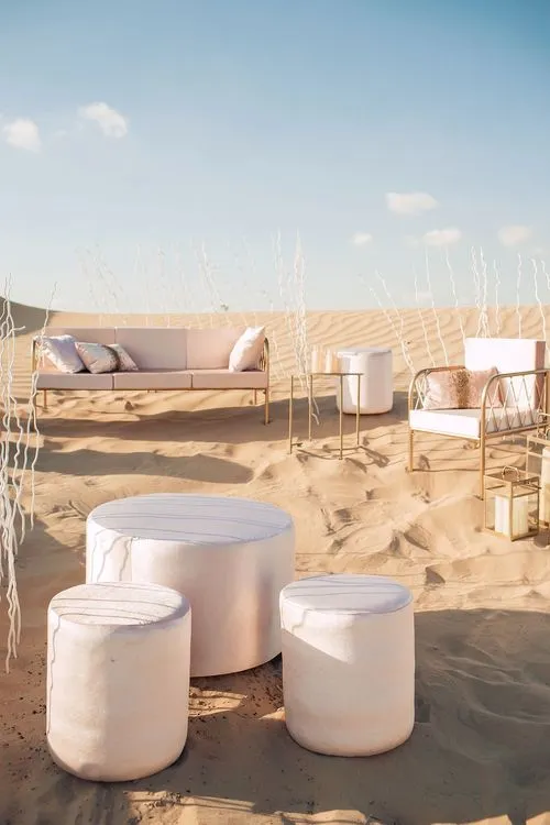 Pink desert lounge setup with ottomans