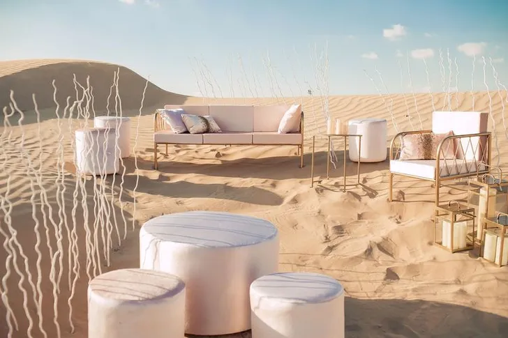 Pink desert lounge setup with ottomans