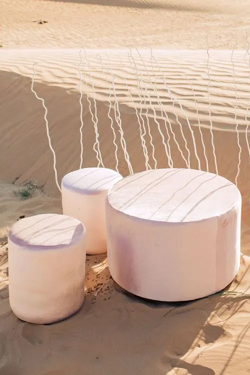 Pink desert lounge setup with ottomans