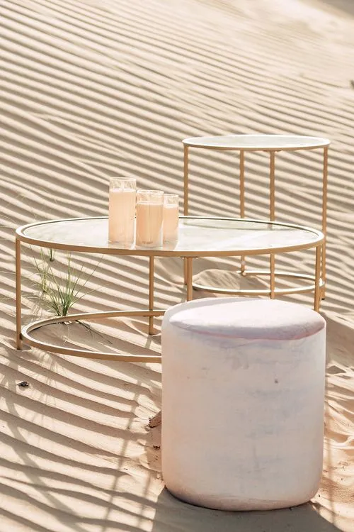 Pink desert lounge setup with ottomans