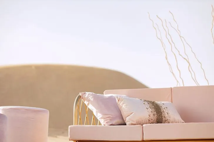 Pink desert lounge setup with ottomans