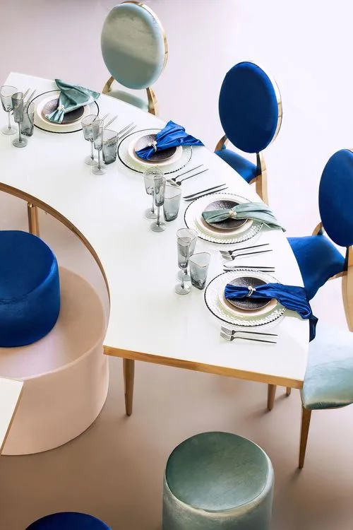 Eye-shaped table with a setup featuring blue accents