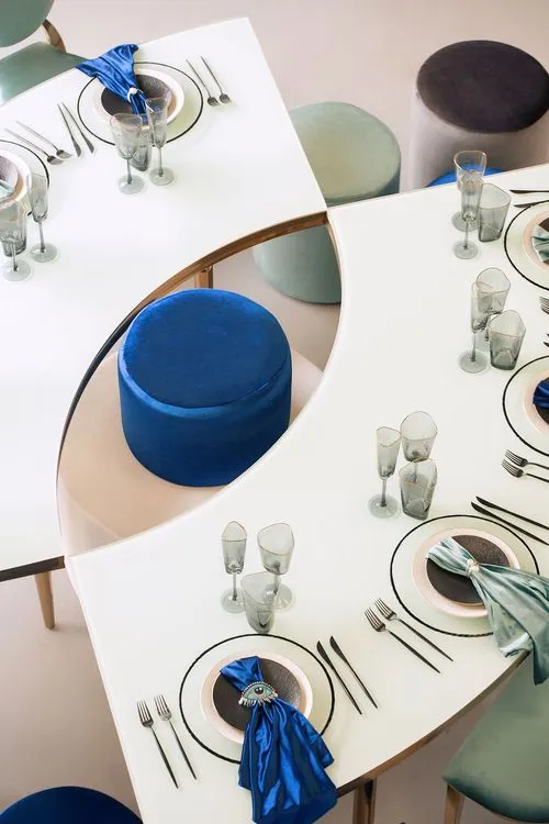 Eye-shaped table with a setup featuring blue accents