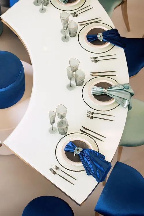 Eye-shaped table with a setup featuring blue accents