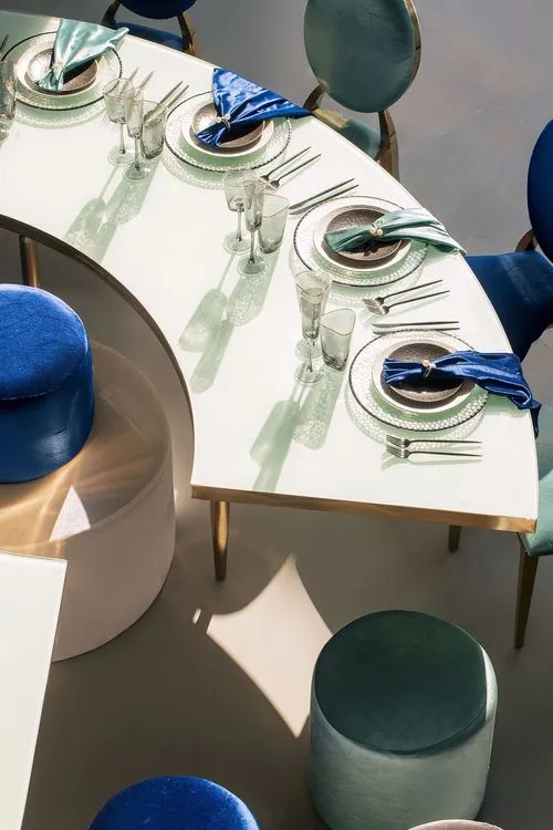 Eye-shaped table with a setup featuring blue accents