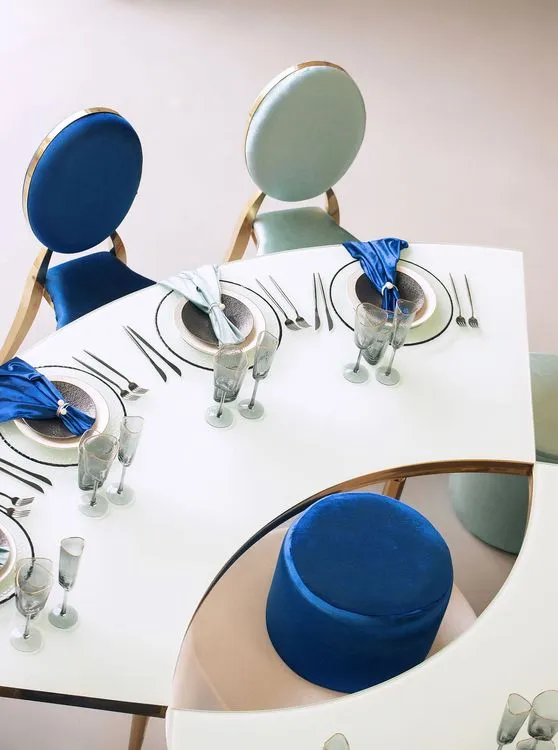Eye-shaped table with a setup featuring blue accents