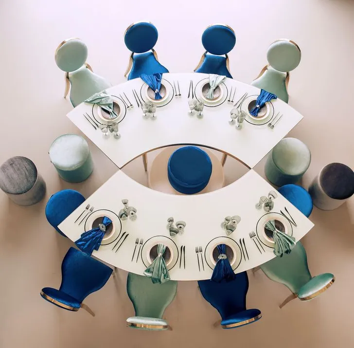 Eye-shaped table with a setup featuring blue accents
