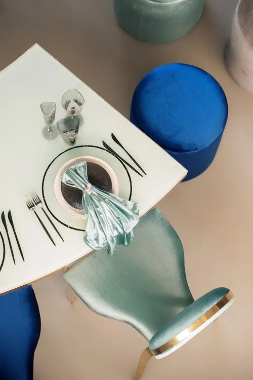 Eye-shaped table with a setup featuring blue accents