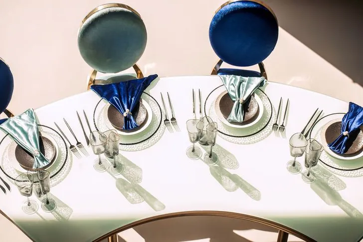 Eye-shaped table with a setup featuring blue accents